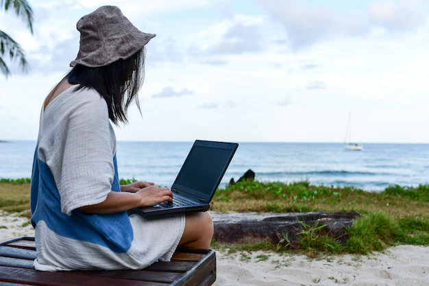 female-travelers-are-using-laptop-computer-on-the-beach_36897-444