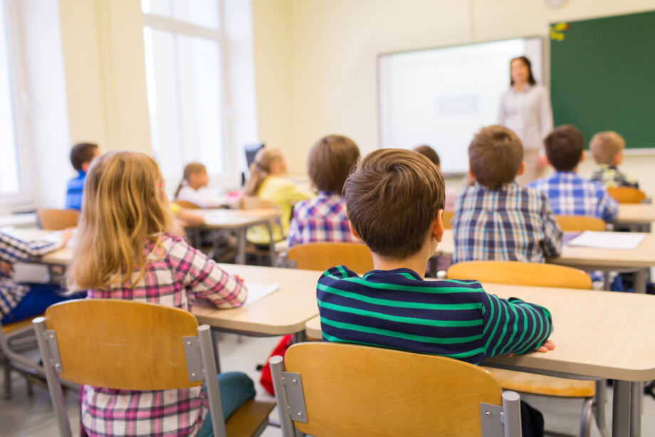 group of school kids and teacher in classroom